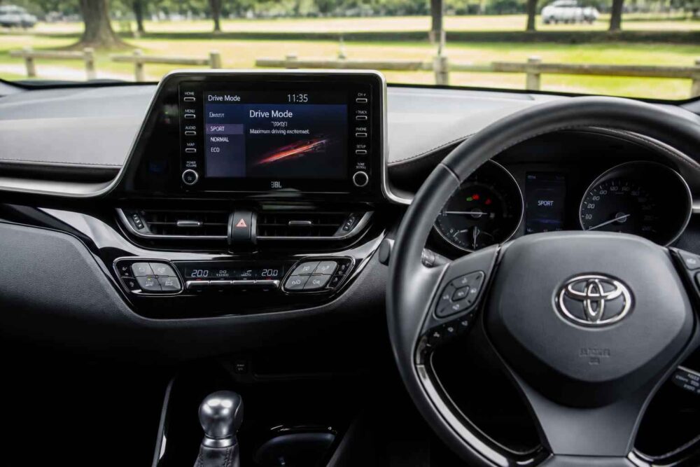 Kokpit Toyoty z centralnym wyświetlaczem Wnętrze Toyoty z ekranem nawigacji, kierownicą i dźwignią automatycznej skrzyni biegów