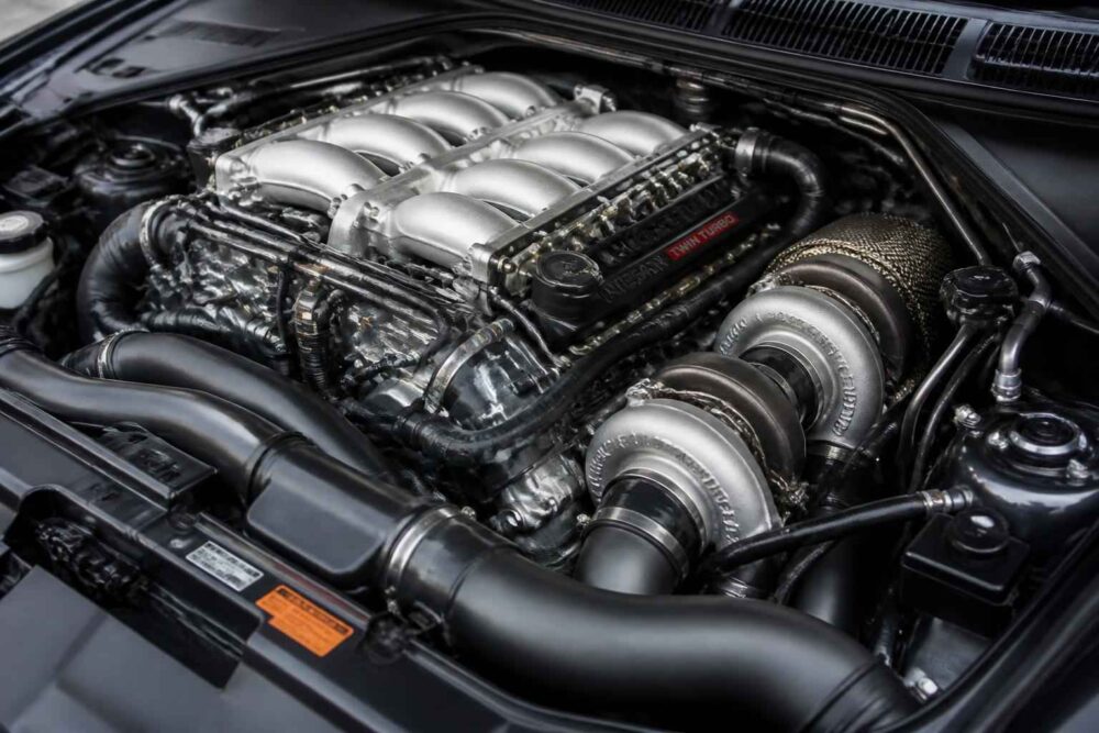 Podwójnie doładowany silnik V8 w komorze auta Widok komory silnika z dwoma turbosprężarkami i srebrnym kolektorem dolotowym